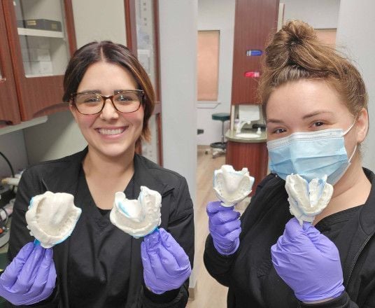 Dental assistant students holding alginate impressions during a hands-on lab
