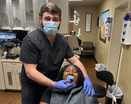 Abilene Dental Assistant student flashing a peace sign while practicing first dental impression with support from a classmate.