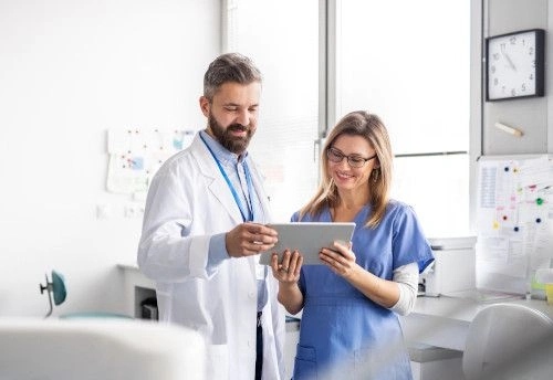 medical assistant reviewing patient electronic health records with doctor