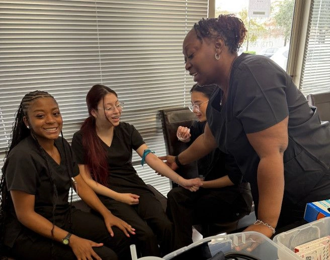 Houston Medical Assistant School instructor supervising students practicing venipuncture